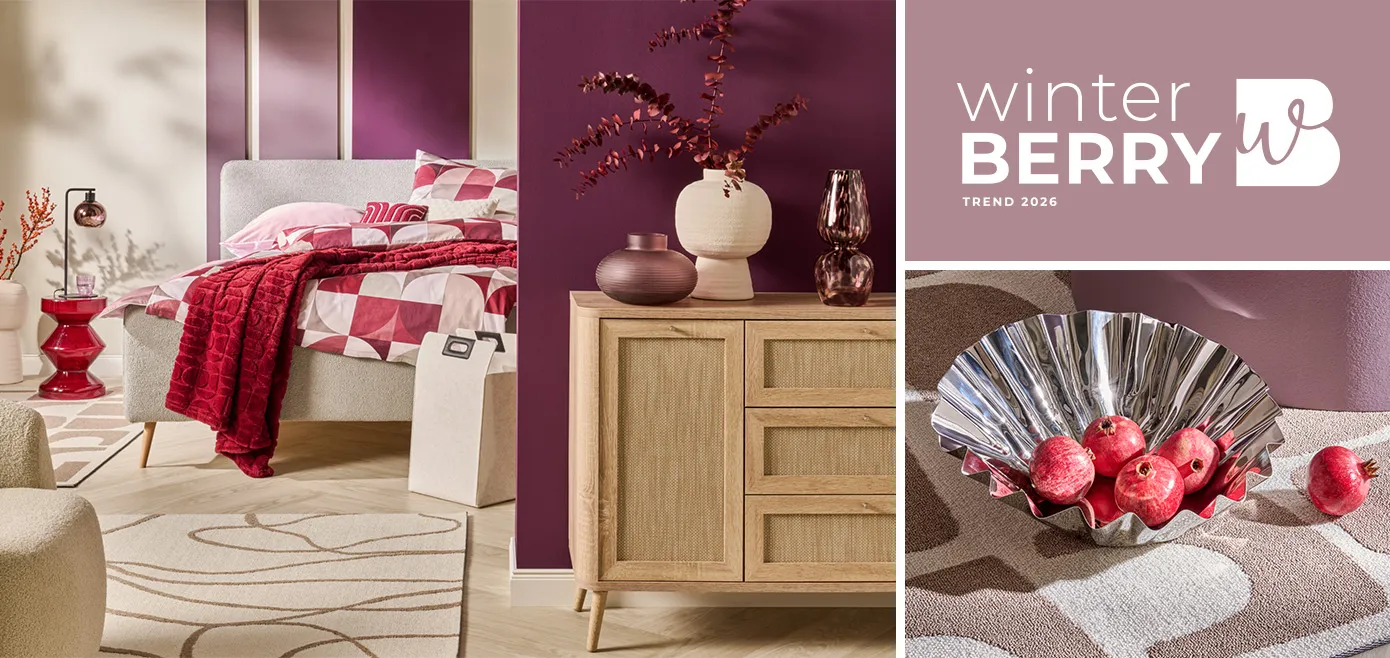 Logo Winterberry, hellgraues Bett mit gemusterter Bettwäsche in Beerentönen, roter Glas-Beistelltisch, cremefarbener Teppich mit braunen geschwungenen Linien, helle Holzkommode in Rattanoptik mit Dekovasen in Creme und Beerentönen