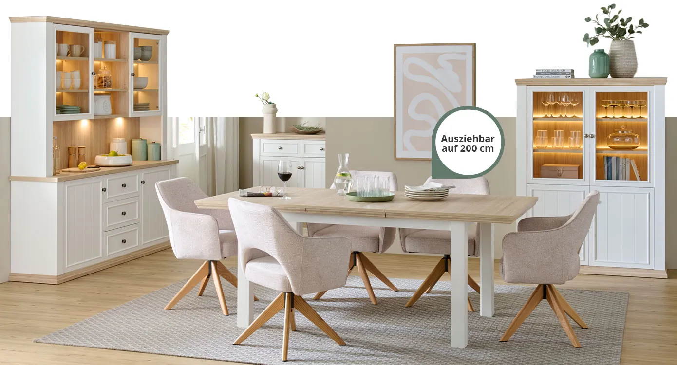Esszimmer mit weißen Möbeln: Buffet und Vitrine mit Beleuchtung, Esstisch mit Hinweistext "Ausziehbar auf 200 cm", dazu 5 Polsterstühle in Rosé