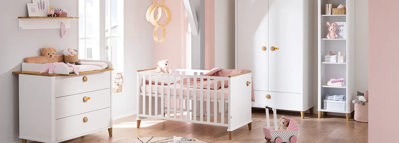 Babyzimmer im Skandi-Stil mit weißen Möbeln mit Holzakzenten, bestehend aus Wickelkommode, Wickelaufsatz mit Aufsatz im Teddy-Design, Wandregal, Babybett, Schrank, Regal, Babaytextilien, Deko und Spielzeug