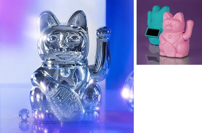 Desktop-Ansicht: Bild 1: Metallic-glänzende hellblaue große Winkekatze. Bild 2: Matte türkise und rosa Winkekatzen mit Solarpaneel. Mobile Ansicht: Bild 1: Solar-Powered 5 cm Winkekatze. Bild 2: Metallic-glänzende hellblaue große Winkekatze