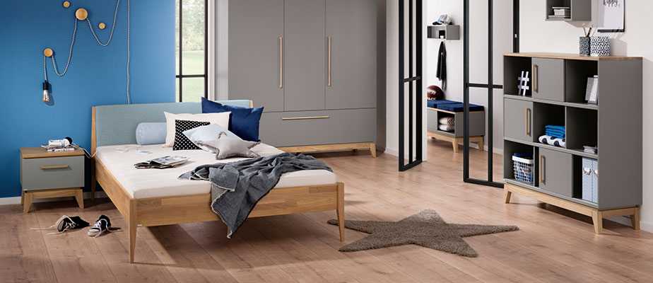 Jugendzimmer in Schiefergrau und Eiche, bestehend aus Bett, Nachtkommode, Schrank, Regal, Deko und Spielzeug