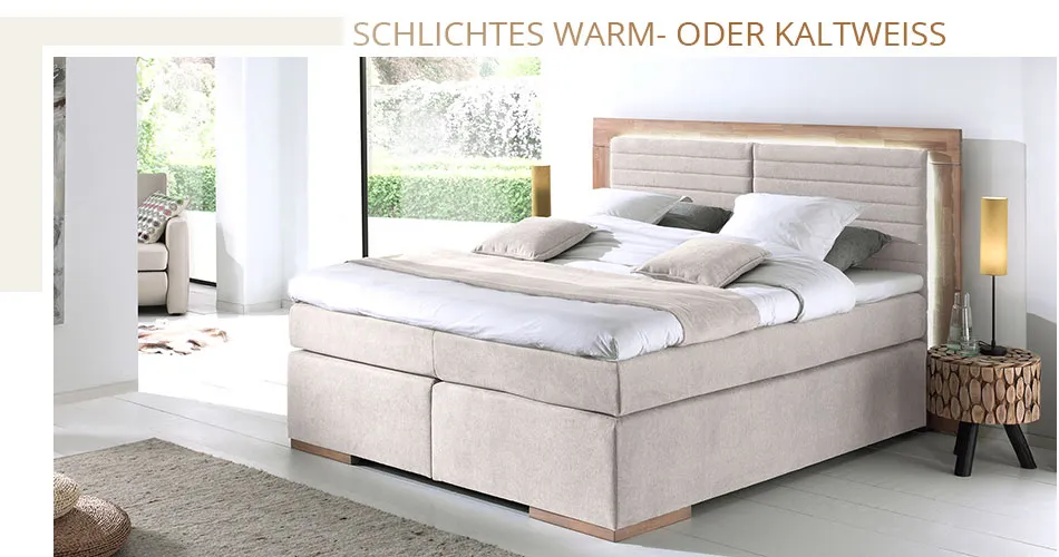 Schlichtes Warm- oder Kaltweiss. Helles Schlafzimmer mit beigem Boxspringbett mit umlaufender weißer Beleuchtung hinter dem Kopfteil