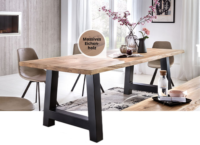 Esstisch mit Holzplatte und schwarzem Gestell in A-Form. Hinweis an der Tischplatte "Massives Eichenholz". Am Tisch 3 schwarze Kufenstühle