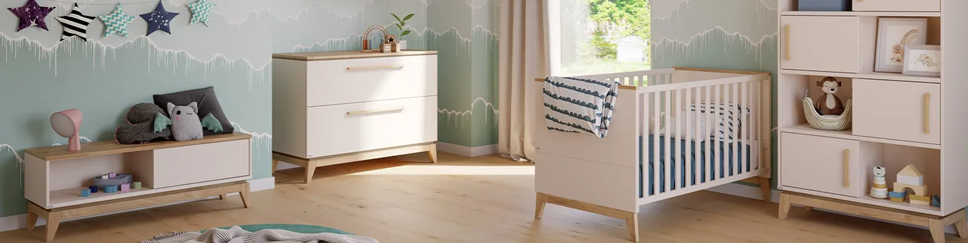 Babymöbel in Cashmere-Beige und Eichenholz im Babyzimmer, bestehend aus Lowboard, Kommode, Wandregale, Kinderbett, Regal mit Schiebetüren, Deko. 
