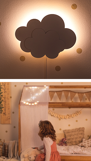 Beleuchtete Wandleuchte in Wolkenform. LED-Lichterkette an Holzhausbett