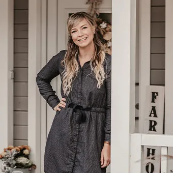 Frau auf Veranda eines Landhauses