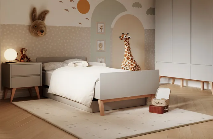 Kinderzimmer im Skandistil mit hellgrauen Möbeln mit Holzakzenten, bestehend aus Nachtkommode, Bett inkl. Bettkasten, Schrank, beiger Teppich mit Muster, Spielzeug, Deko.