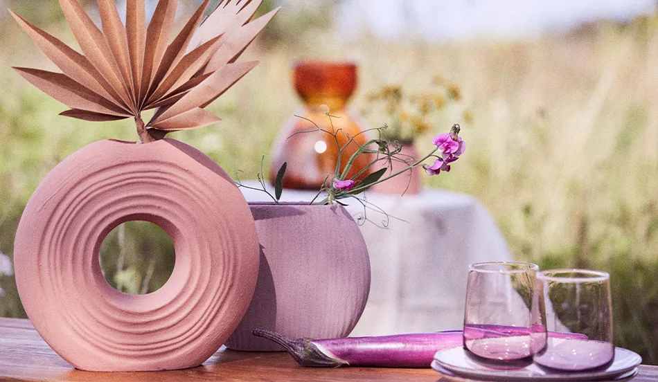 Lila Vasen mit pinken Blumen, lila Gläsern