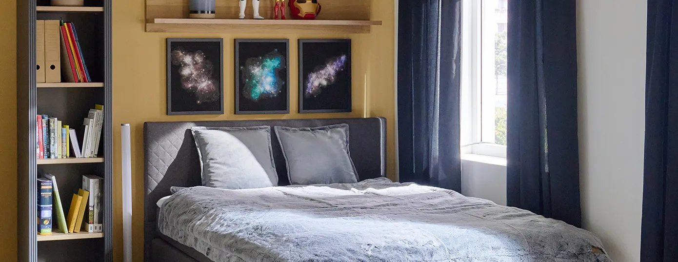 Graues Bett mit LED-Stehleuchte, graues Standregal und Galaxy-Dekobildern und Star Wars Figuren