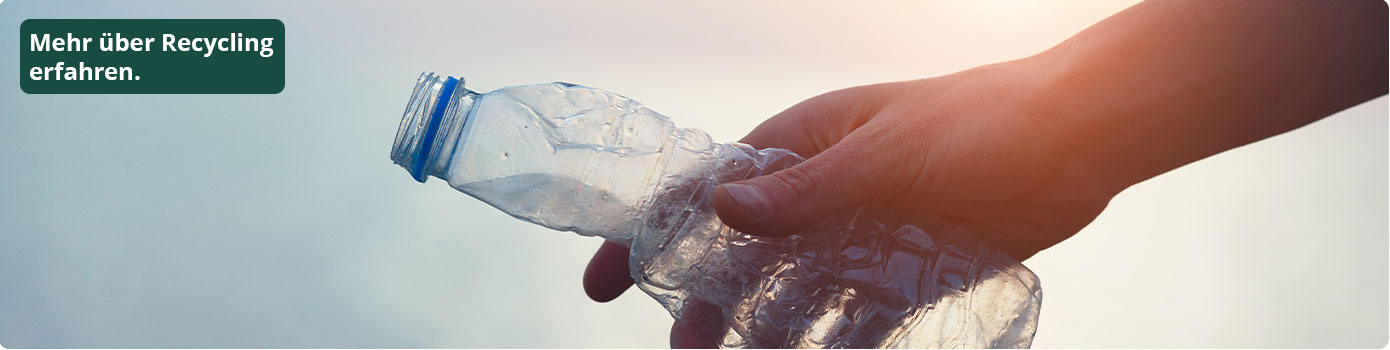 Mehr über Recycling erfahren. Hand hält leere Plastikflasche.