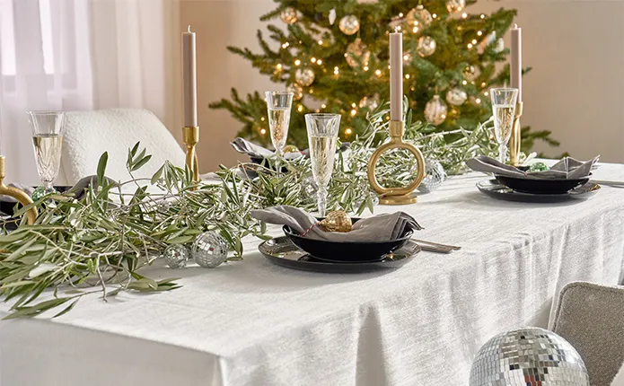 Schwarzes Geschirr, Champagner-Gläser, Diskokugeln und Sträucher als Deko, goldene Kerzenhalter