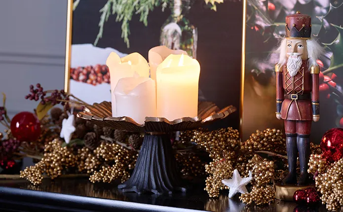 Detailansicht Deko Kommode mit Nussknacker. roten Weihnachtskugeln, goldenen Beerensträuchern, schwarze Schale mit 4 Kerzen