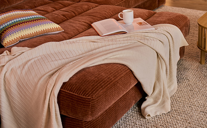 Braunes Cord-Ecksofa mit großer Liegefläche, beige Decke