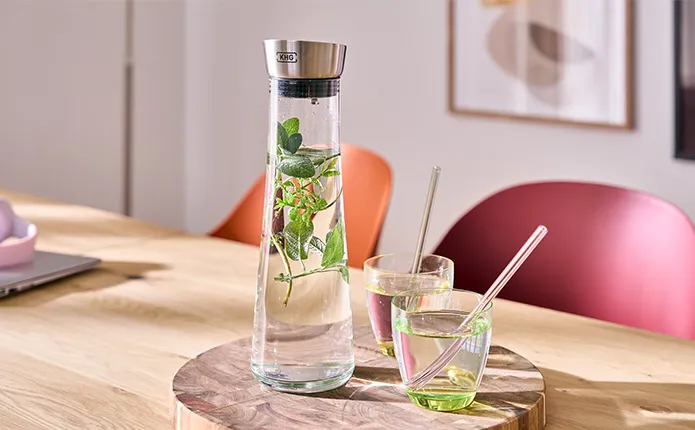 Detailansicht Holzbrett mit Wasserkaraffe und Trinkgläsern