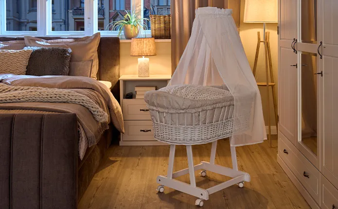 Rollbarer Stubenwagen neben Doppelbett