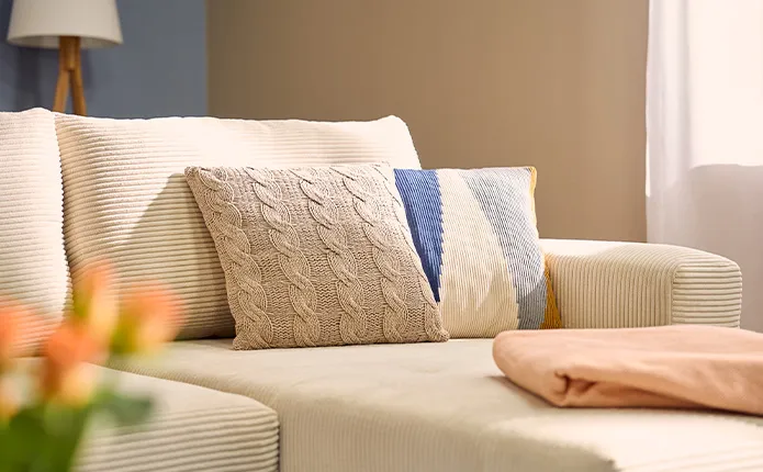 Dekokissen in Flechtoptik und geometrischen Formen auf Sofa