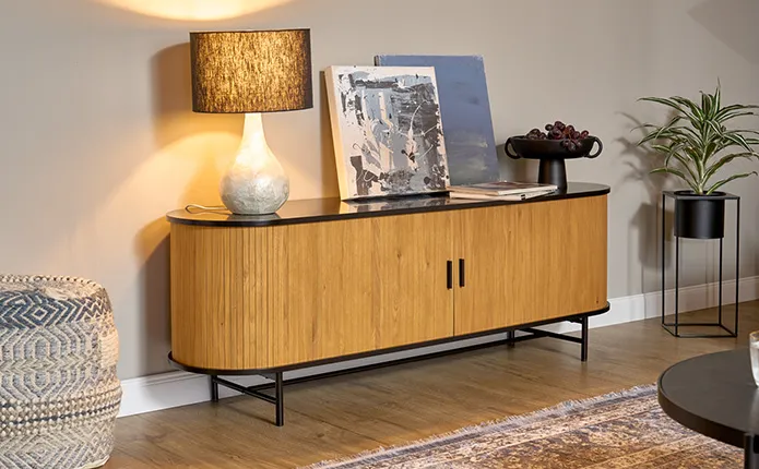 Kommode in ovaler Form in Lamellenoptik aus Holz mit schwarzen Applikationen