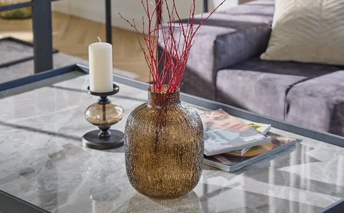 Vase mit rotem Trockenstrauch auf Tisch