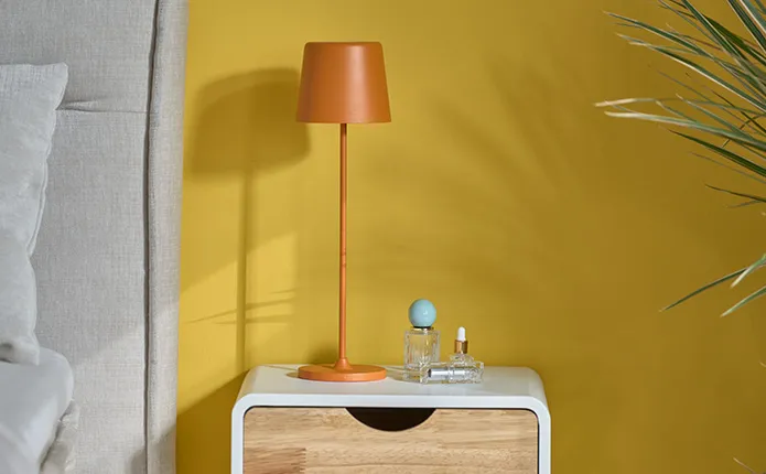 Wand in Senfgelb, Akku-Tischleuchte in Orange