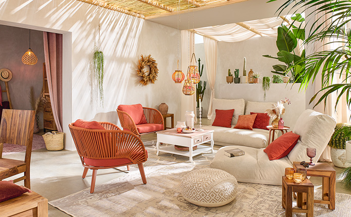Beige Relaxliegen mit Terracotta- und orangefarbenen Kissen, Pendelleuchten in Flechtoptik, Pflanzen