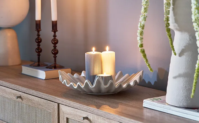 Detailansicht Muschelschale in Beige mit LED-Kerzen auf Holzkommode und braune Kerzenhalter