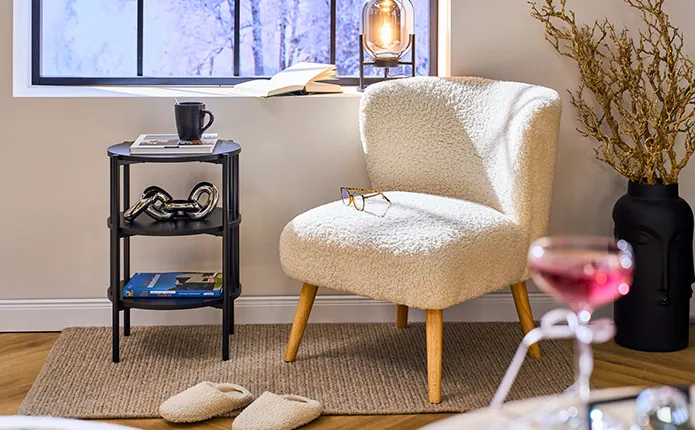 Kleiner Sessel aus Boucléstoff mit kleinem schwarzen Beistelltisch und Chromdeko, schwarze Vase