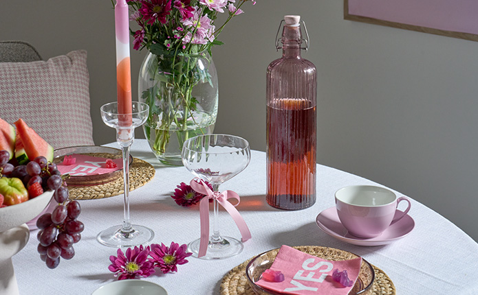 Detailansicht rosane Wasserflasche, Coupette-Gläser und rosane Tassen