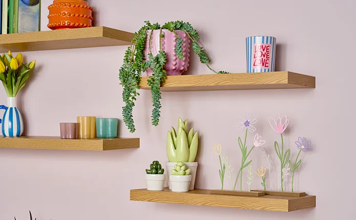 Vier versetzte Wandregale mit verschiedenen Dekovasen, Frühlingsdeko, Übertöpfen mit Pflanzen und Teelichthaltern