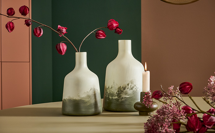 Detailansicht gemustertes Geschirr in Rosa und Weiß, Glas-Dekovase und Kerzenständer