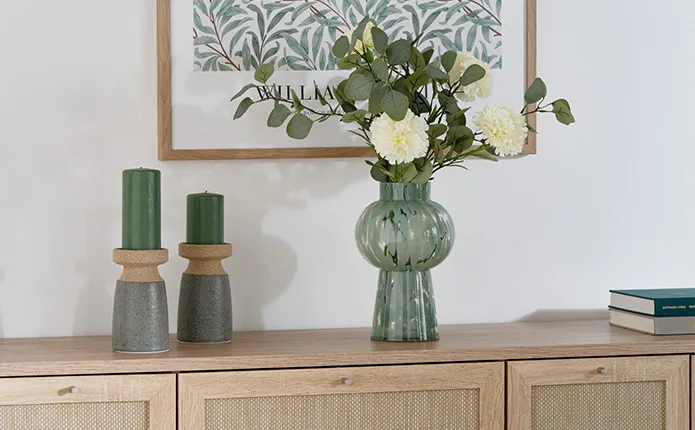 Detailansicht grüne Vase und Kerzenständer auf Kommode