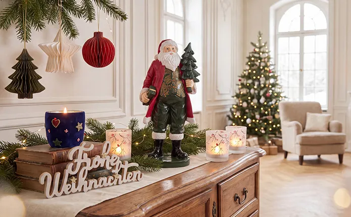 Dekofigur Weihnachtsmann sowie Weihnachtsteelichter auf Kommode