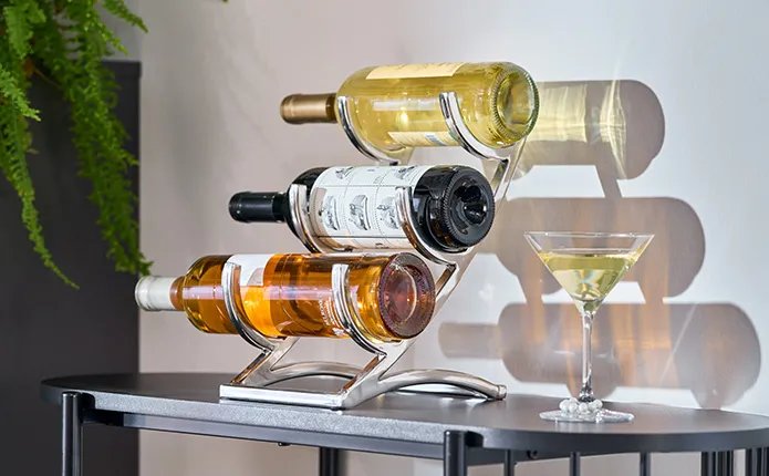 Detailansicht Weinhalter in drei Ebenen in Chrom mit Weinflaschen, daneben Martiniglas