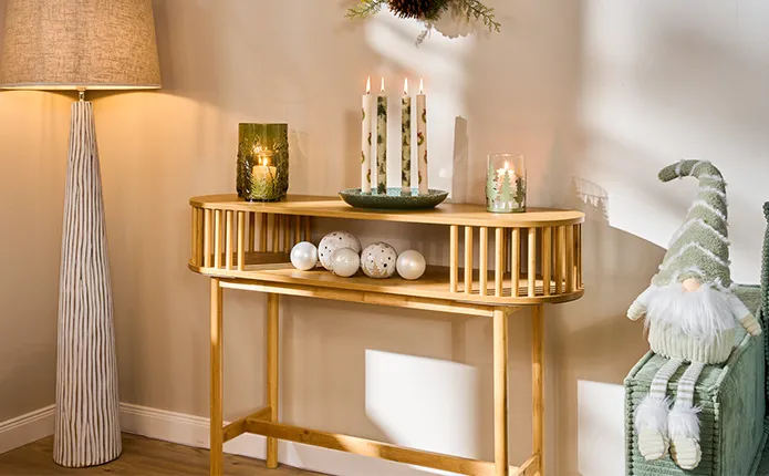 Filigraner Holz-Konsolentisch mit Holzsträben und ovaler Form mit Salbeigrünen Dekoartikeln zu Weihnachten wie eine Adventskranz-Schale mit 4 Stabkerzen, grünes Windlicht, weißen Christbaumkugeln und einem Stoffwichtel