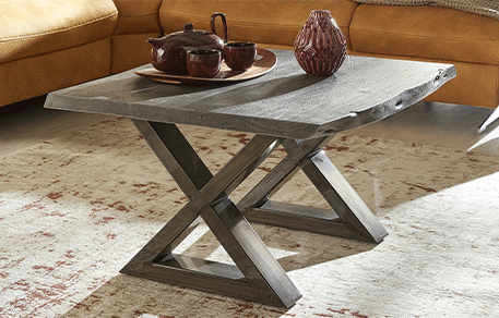 Couchtisch mit grauer Holzplatte mit Baumkante, dunkles Metallgestell in X-Form