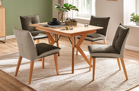 Essgruppe bestehend aus Holz-Esstisch und Polsterstühlen mit grün-grauen Bezügen