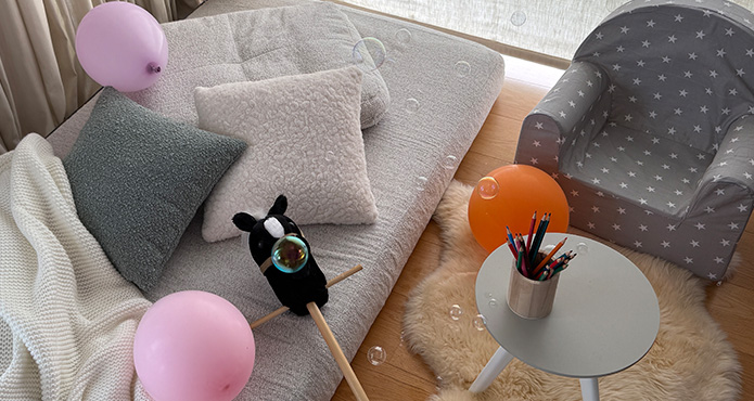Gemütliche Sitz- und Spielecke mit Seifenblasen, Steckenpferd, Luftballons