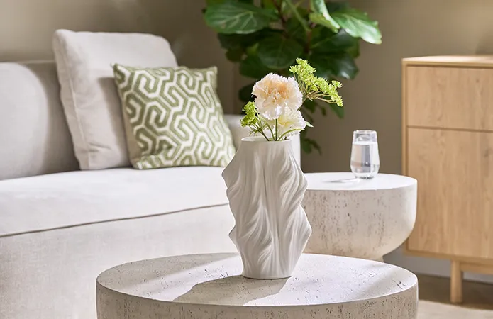 Detailansicht weiße Keramikvase in Freiform auf Couchtisch