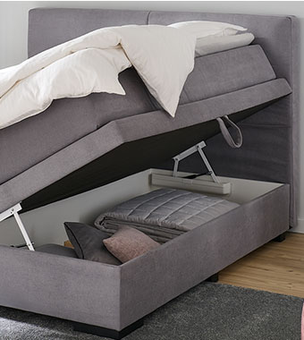 Graues Boxspringbett mit Bettkasten