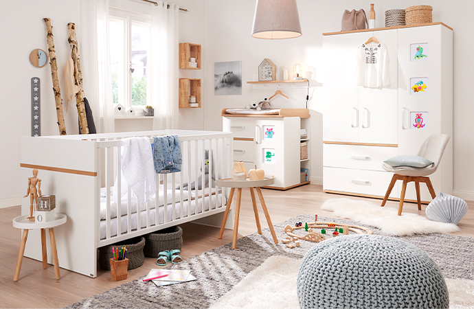 Weiße Babyzimmermöbel mit Holzakzenten, Bilderrahmen in den Schrankfronten