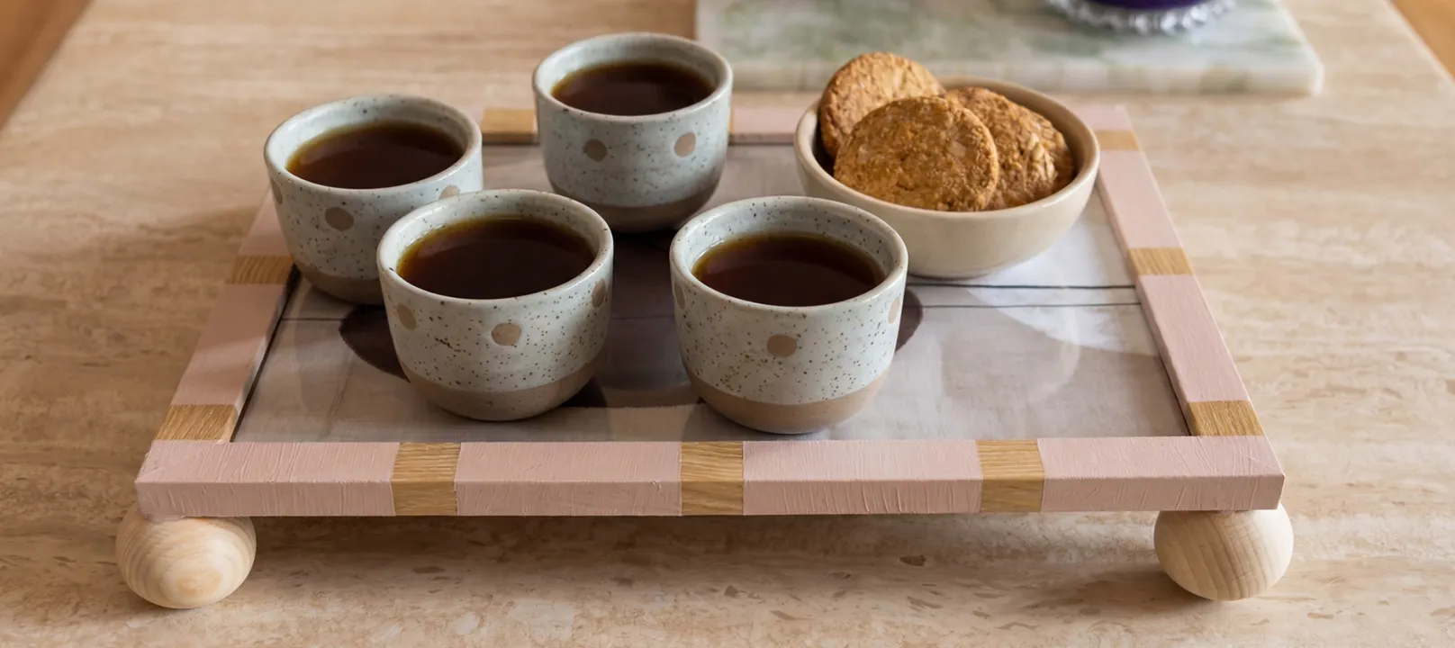 Bemalter Bilderrahmen mit runden Holzfüßen als Serviertablett mit 4 kleinen Teetassen und Crackern