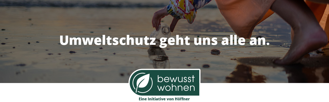 Umweltschutz geht uns alle an. bewusst wohnen. Eine Initiative von Höffner. Person hebt leere Plastikflasche am Strand auf