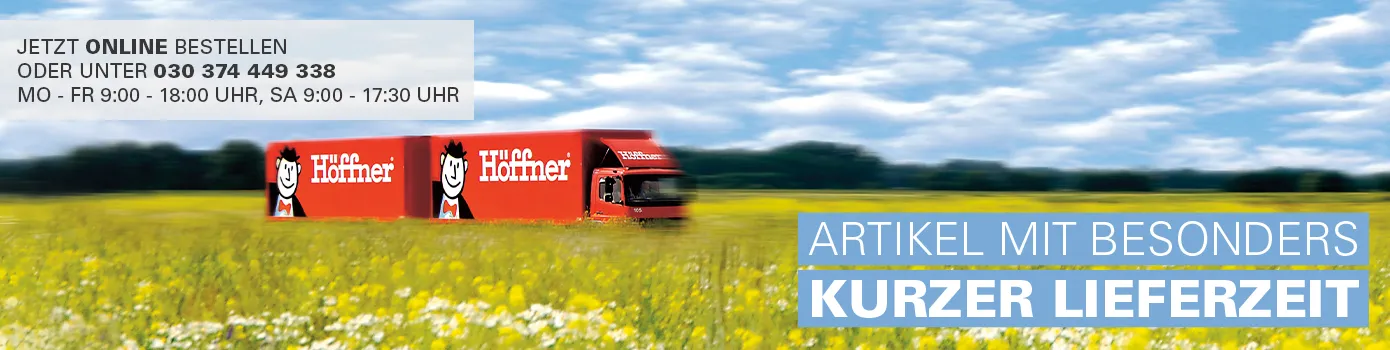 Jetzt online bestellen oder unter 030 374 449 338 - Mo-Fr 9 -18 Uhr, Sa 9-17.30 Uhr - Artikel mit besonders kurzer Lieferzeit -roter Höffner-LKW mit zwei Hängern, der durch eine Blumenwiese fährt im Hintergrund Bäume und der Himmel