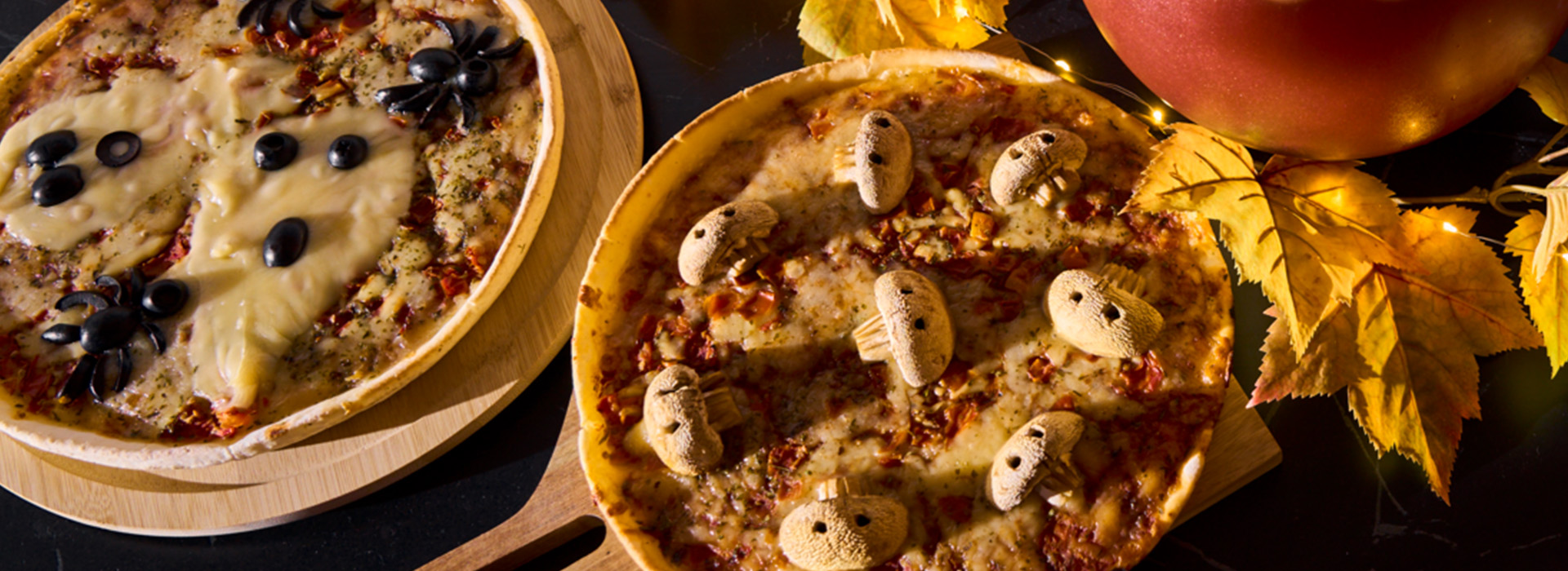 Pizza mit Pilzen als Totenköpfen und Oliven als Spinnen