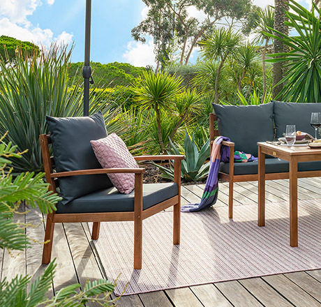 Gartenmöbel aus Eukalyptusholz auf Terrasse umgeben von Palmen