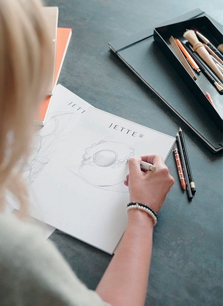 Nahaufnahme der Hand von Designerin Jette Joop, wie sie gerade eine Skizze anfertigt
