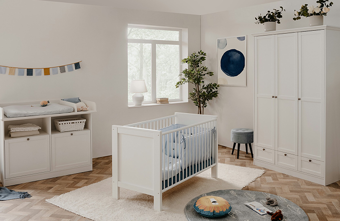 Weiße Landhausmöbel mit Rahmenfronten fürs Babyzimmer