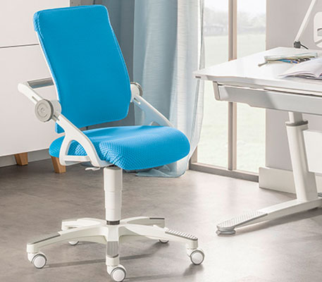 Blau-weißer Schreibtischstuhl neben weißem Schreibtisch in einem Kinderzimmer