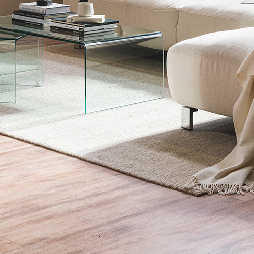Helle Couch, Couchtisch aus Glas, beiger Teppich
