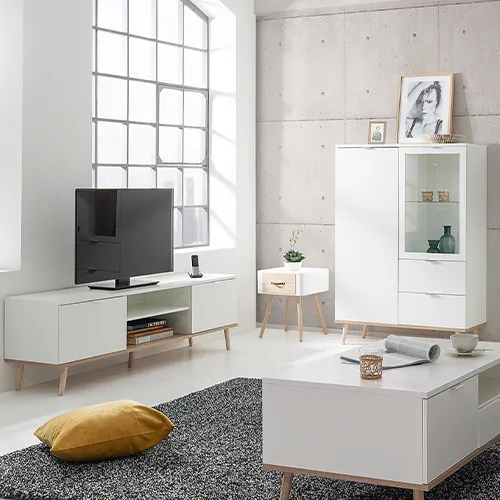 Wohnzimmer mit diversen Wohnzimmermöbeln in Weiß und Holzoptik im Skandi-Stil, grau gemusterter Teppich, Deko