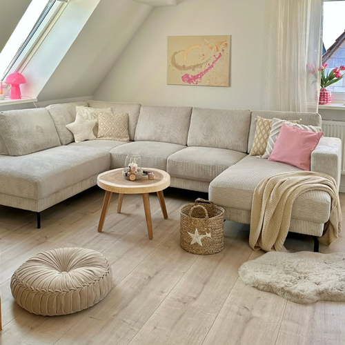 Wohnlandschaft mit poppigen rosanen Accessoires